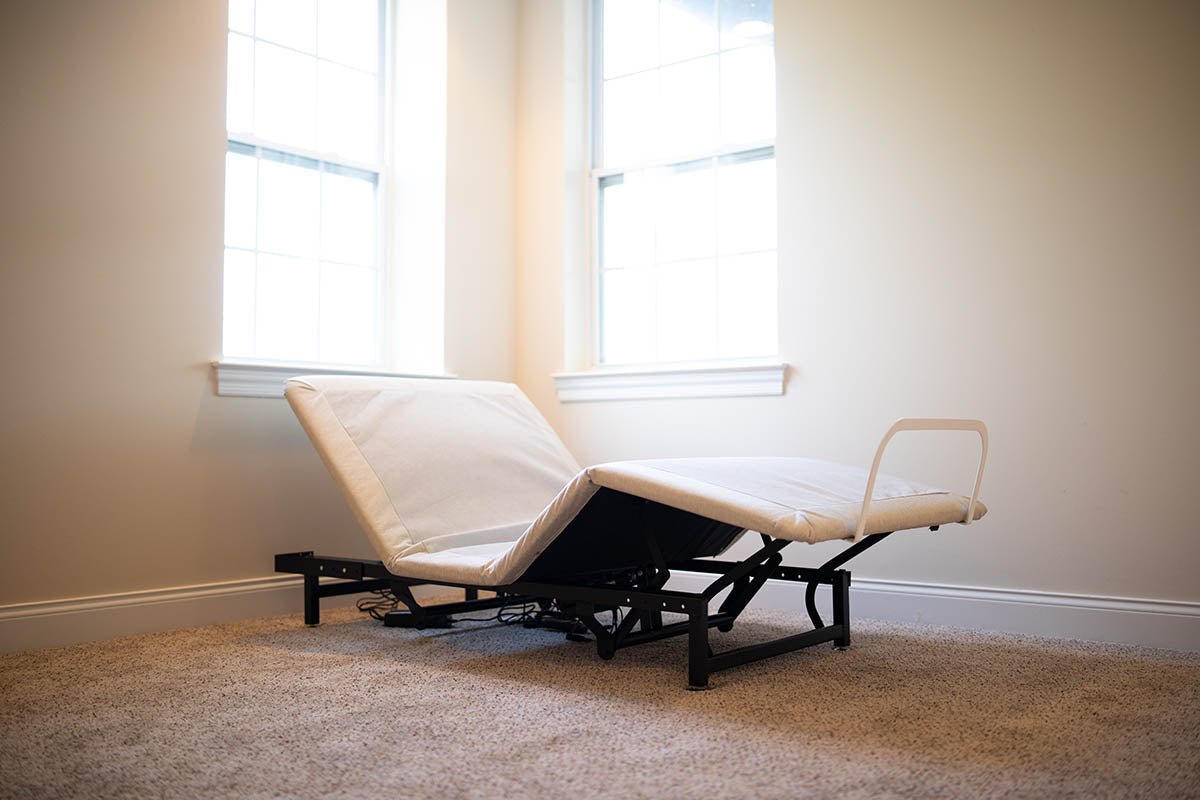 A low-angle view of the affordable Flexabed Value-Flex adjustable bed base, without the full mattress, showing the exposed black adjustable frame. The head and foot sections are inclined.