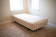 The Flexabed Value-Flex adjustable bed is shown flat, featuring the optional quilted Innerspring mattress in a bright, empty room