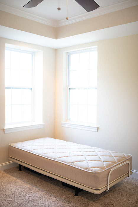 The Flexabed Value-Flex adjustable bed is shown flat in the corner of a room, featuring an optional quilted Innerspring mattress