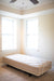 The Flexabed Value-Flex adjustable bed is shown flat in the corner of a room, featuring an optional quilted Innerspring mattress