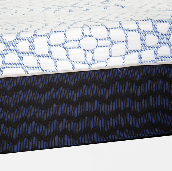 A side-profile close-up highlighting the contrast between the plush white top layer and the supportive, patterned dark blue base layer.