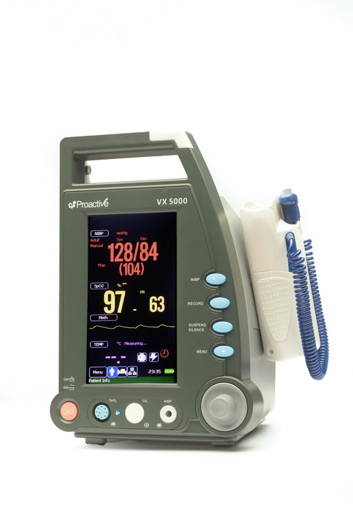 Protekt VX 5000 vital signs monitor powered on, showing blood pressure, SpO₂, pulse rate, and temperature readings on a bright color display