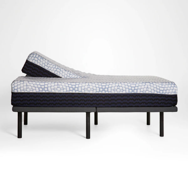 A side-profile view of the mattress on an adjustable frame, showcasing the flexibility of the split-head design as it leans upward.