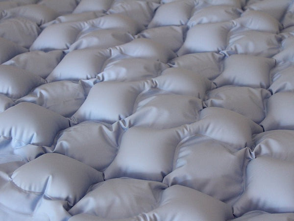 Close-up view of the Protekt Aire 1500 alternating pressure mattress overlay, showing the bubble-style air cell design for even pressure distribution