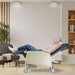 Geri chair with blue upholstery in reclined position, showing foot rest and locking casters with an elderly woman relaxing with her eyes closed