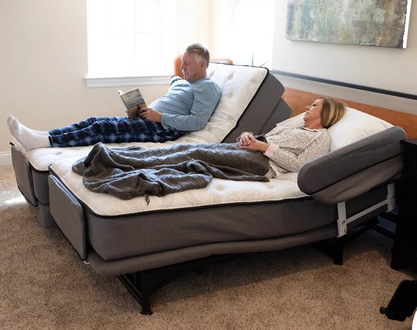 Older couple relaxing on Flexabed Premier adjustable beds with one of the beds reclined, demonstrating independent adjustability and comfort