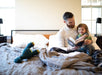 Father reading to child on a Flexabed Premier adjustable bed, emphasizing comfort, relaxation, and quality time