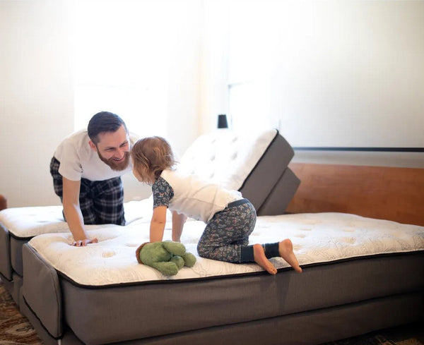 Father and child playing on Flexabed Premier adjustable beds, showcasing safety and flexibility for home use
