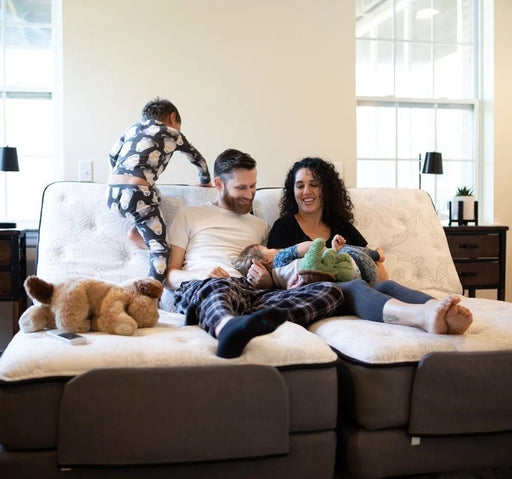 Family relaxing together on a dual Flexabed Premier adjustable bed, showing comfortable lounging positions and spacious design