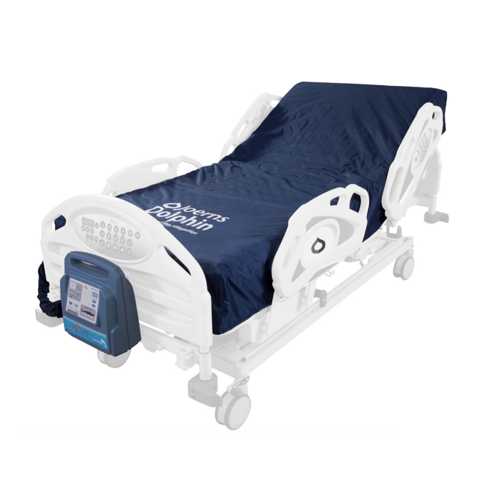 The Dolphin Pediatric Mattress System installed on a pediatric-sized hospital bed. A light blue control unit is attached on the footboard of the bed. The bed frame itself is greyed out and slightly transparent, conveying that it is not included in the product. The words "Joerns Dolphin" are printed on the lower section of the mattress.