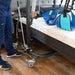 Close-up of a caregiver operating a Hoyer lift beside a Flexabed Hi-Low adjustable bed with optional mattress, showing mobility assistance equipment