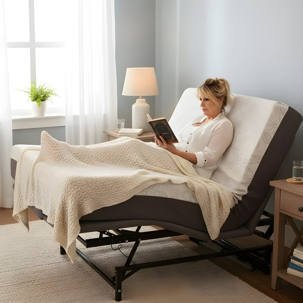 Woman relaxing and reading a book while reclined on a Flexabed Hi-Low adjustable bed with an optional mattress, in a softly lit bedroom