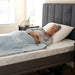Older woman peacefully sleeping on a Flexabed Hi-Low adjustable bed with an optional mattress, head slightly elevated for comfort