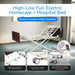 Full view of the High-Low Full Electric Homecare + Hospital Bed, showcasing its adjustable features for comfort and safety. The bed has a single-touch central lock for enhanced safety, caster guide lock to keep the bed secure in place, and a retractable bumper guard that protects walls from scratches and scuff marks. The bed is shown with a wooden headboard and a modern room setting in the background.
