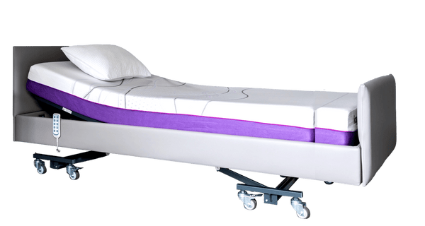 A high-angle studio shot of the iCare IC333EL extra-long adjustable bed in a sleek grey finish. The head of the bed is elevated, showing the ergonomic break in the mattress. A wired remote hangs from the side rail, and the unit is mounted on heavy-duty locking casters.