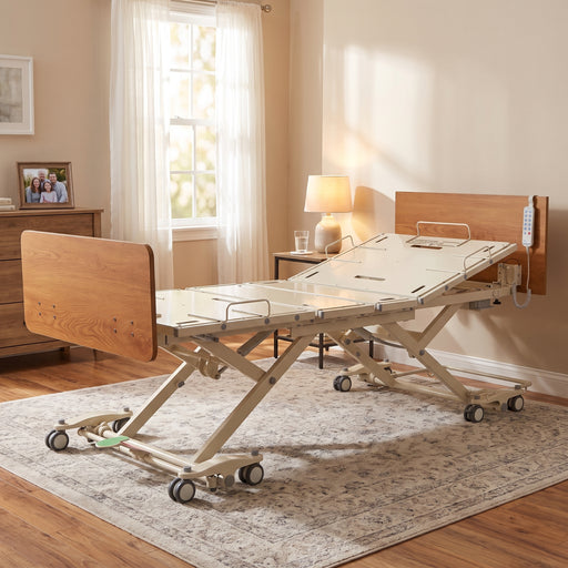 Adjustable medical bed with raised side rails, wooden headboard and footboard, remote control, and wheeled base in a home bedroom.