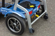 A close-up view of the rear section of the blue scooter. It highlights a large rear wheel with a silver-rimmed hub and the "So Lite S1" branding on the frame. Two small black anti-tip wheels are visible at the very back for added stability.