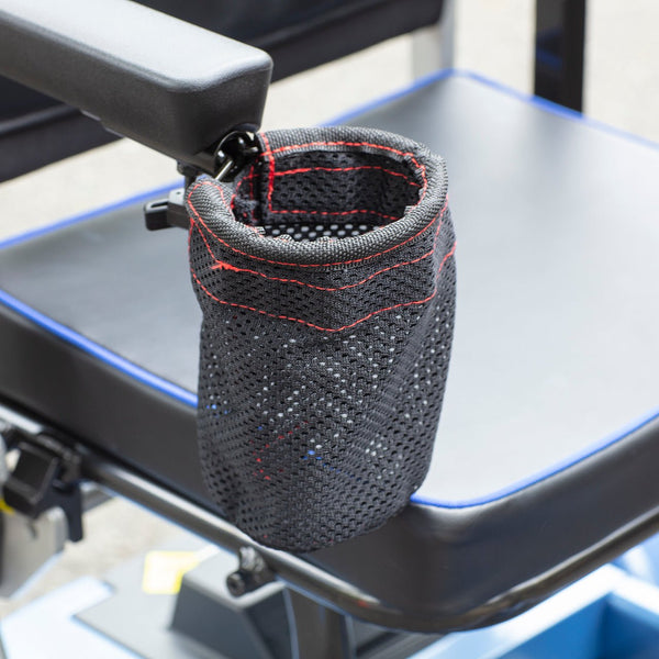 A detailed close-up of a black mesh beverage holder attached to the armrest of the Journey So Lite® scooter. The holder features red stitching and is shown positioned next to the black cushioned seat, which has blue piping along the edge.