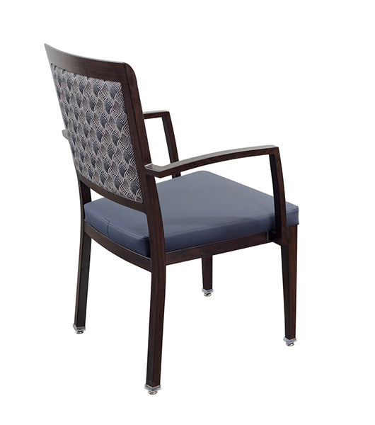 Dining chair with arms for assisted living furniture - aluminum wood grain frame with patterned square backrest and blue upholstered seat cushion, featuring armrests and metal floor glides, angled view on white background