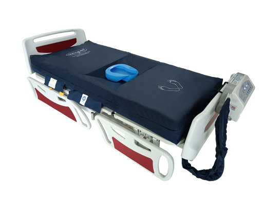 A high-resolution photo of the ObboMed OB-1620 medical air mattress system against a transparent background. The navy blue mattress is shown on a white and red hospital bed frame. It features a central recessed area with a blue bedpan, white foot-placement icons at the base, and a control unit mounted on the footboard with a thick blue air hose connecting to the mattress.