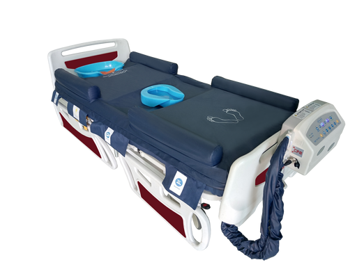 A high-quality photograph of the OB-1680 alternating air mattress system. The navy blue mattress is shown with its inflatable guardrails raised, a blue bedpan in the center, and a light blue shampoo basin at the head. The control unit is attached to the foot of the white and red bed frame, with a CPR emergency release tag clearly visible on the side of the pump.