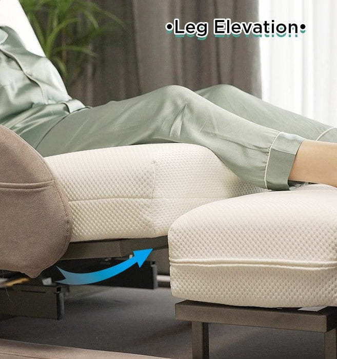 A person in light green pajamas reclines on the Starsleep Orin Rotating Bed with their legs elevated on an ottoman. An arrow points to the leg elevation feature, and “Leg Elevation” is shown above their legs.