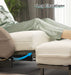 A person in light green pajamas reclines on the Starsleep Orin Rotating Bed with their legs elevated on an ottoman. An arrow points to the leg elevation feature, and “Leg Elevation” is shown above their legs.