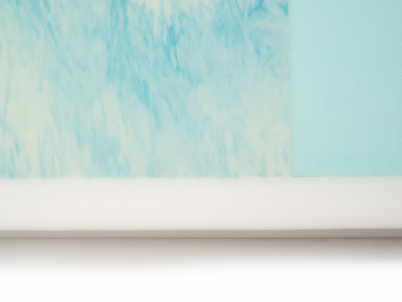 Close-up view of the Protekt 500's two-layer foam core, showing the top light blue therapeutic foam layer and the firm white perimeter edge.