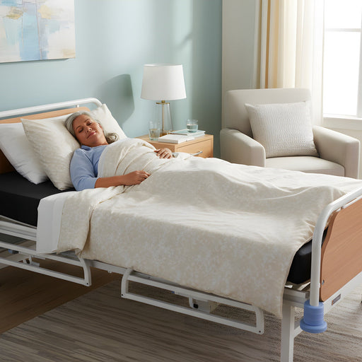 A middle-aged woman sleeping comfortably on a 60" Protekt 600 Bariatric Foam Mattress installed in a hospital bed