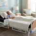 A middle-aged woman sleeping comfortably on a 60" Protekt 600 Bariatric Foam Mattress installed in a hospital bed