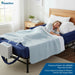 Woman resting comfortably on the Protekt Aire 6000AB alternating pressure air mattress with raised side bolsters, connected to the digital pump at the foot of the bed