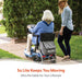 An elderly woman riding blue Journey So Lite folding mobility scooter outdoors on paved path, accompanied by a younger woman, with tagline 'So Lite Keeps You Moving - Ultra Portable for Your Lifestyle