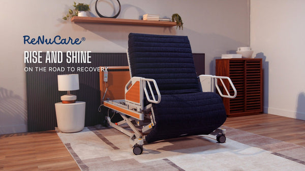 A cozy, well-lit room with wooden floors, rug, and shelves features a modern healthcare recliner and displays the ReNuCare Standing Bed—a 4-position adjustable hospital bed—highlighting comfort on the road to recovery.