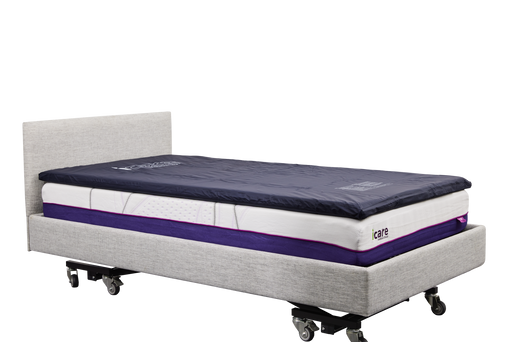 A side-angle, full-length view of an IC333 adjustable bed fitted with a dark blue ActiveFloat medical mattress overlay, showcasing the complete bed assembly.
