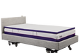 A side-angle, full-length view of an IC333 adjustable bed with a white, plush ActiveX mattress overlay placed on top of the main mattress.