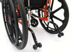 Close-up of the rear anti-tipper assembly and large rear wheels on an orange Ziggo Pro wheelchair, designed to prevent backward falls during reclining.
