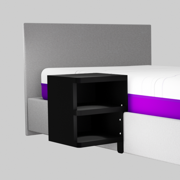 A compact, two-tier shelf unit finished in matte black. It is designed to mount directly to the ICARE bed frame, serving as a floating nightstand.