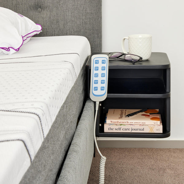 A compact, two-tier shelf unit finished in matte black. It is designed to mount directly to the Icare bed frame, serving as a floating nightstand.
