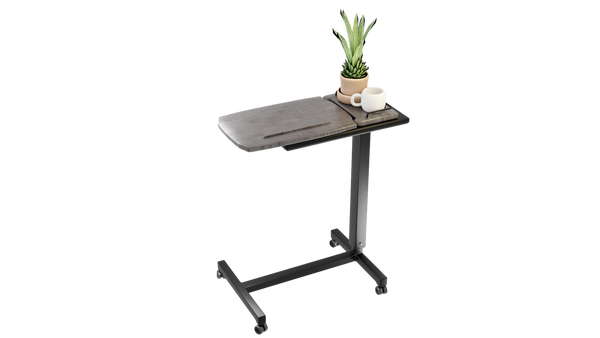 A studio shot of the Icare over bed table isolated on a white background, featuring a wood-grain top, a side tray with a plant and a mug, and a black metal frame with wheels.