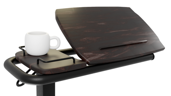 A close-up, side-angle view of the Icare over-bed table, showing the wood-grain surface tilted upwards with a book-rest groove. A white mug sits on the adjacent fixed side tray.