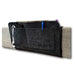 A close-up, angled view of the charcoal felt pouch showing its multi-pocket organization. A pair of white earbuds hangs from the side, a TV remote is tucked into one of the back pockets, a blue pen is clipped to a front pocket, and a book or magazine is visible in the large full-width rear compartment. The icare logo is subtly embossed on the bottom right of the front panel.