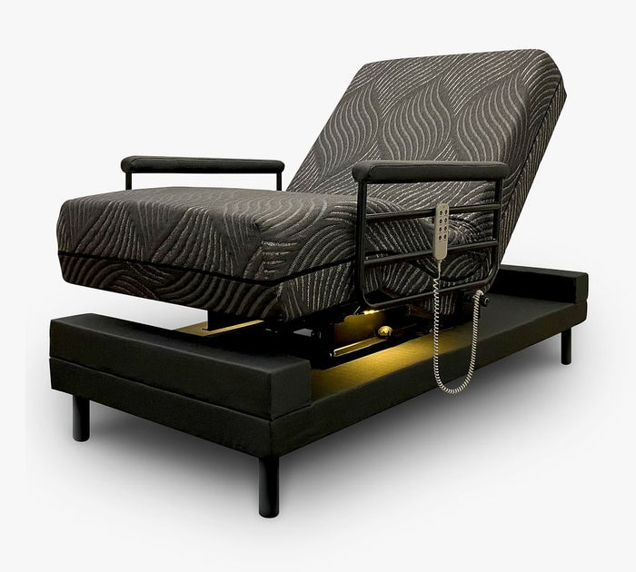 The UPbed Independence Adjustable Bed for Seniors by Journey Health features a patterned dark cushion, armrests, corded remote control, raised headrest, black frame, and under-bed lighting for convenience and fall prevention.