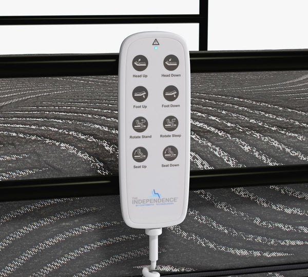 The UPbed Independence Adjustable Bed for Seniors by Journey Health includes a white remote with eight labeled buttons for head, foot, seat, rotate, and sleep functions—great for fall prevention. Shown resting on dark, patterned fabric.