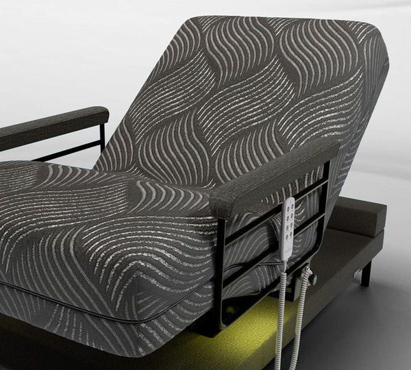 The UPbed Independence Adjustable Bed for Seniors by Journey Health features a black and gray wavy cover, raised backrest, black armrests, remote control on the side, and sits elevated on a platform base for improved fall prevention.