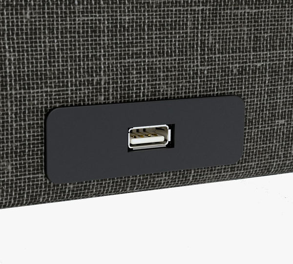 Close-up of a USB port on the UPbed Independence Adjustable Bed for Seniors by Journey Health—conveniently built into a black panel on textured fabric, offering comfort and fall-prevention features for senior safety.