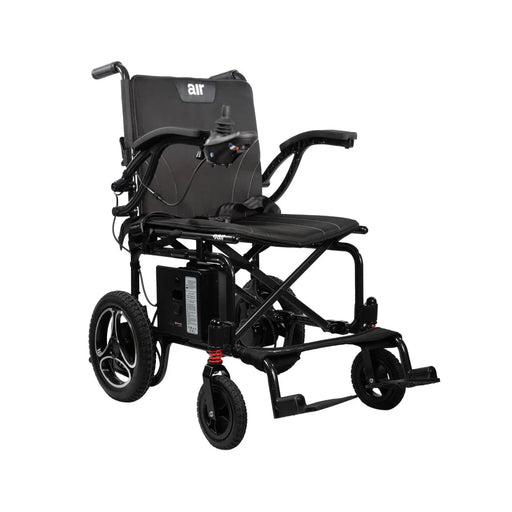 A front three-quarter view of the Journey Air 2026 power chair. It features a sleek black liquid die-cast aluminum frame, memory foam seat and back cushions, and a joystick controller on the right armrest.