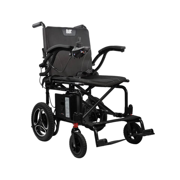 A front three-quarter view of the Journey Air 2026 power chair. It features a sleek black liquid die-cast aluminum frame, memory foam seat and back cushions, and a joystick controller on the right armrest.