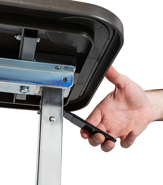Hand operating black height adjustment lever mechanism underneath composite tabletop surface