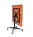 Square tilt top dining table tilted view displaying Biltmore Cherry wood grain surface with black folding base and wheel casters