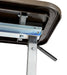 Underside view of an overbed table showing the height adjustment mechanism underneath a composite tabletop